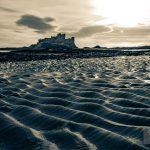 Bambrugh castle across waves of rippled sand